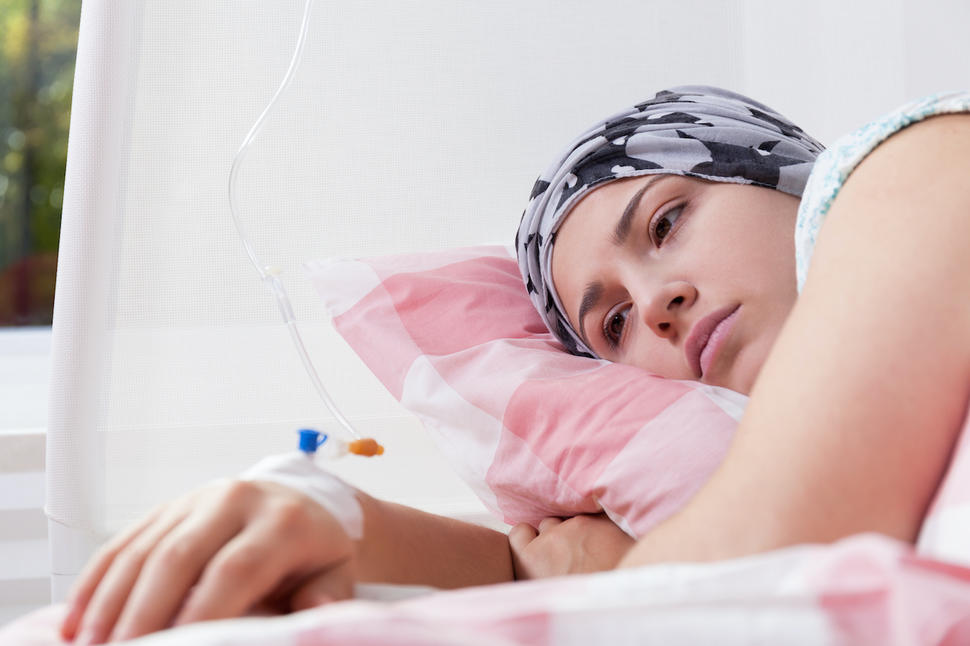 Woman lying in bed and receiving cancer treatment through an IV