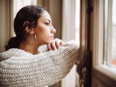 Woman looking sad while gazing out the windo