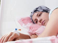 Woman lying in bed and receiving cancer treatment through an IV