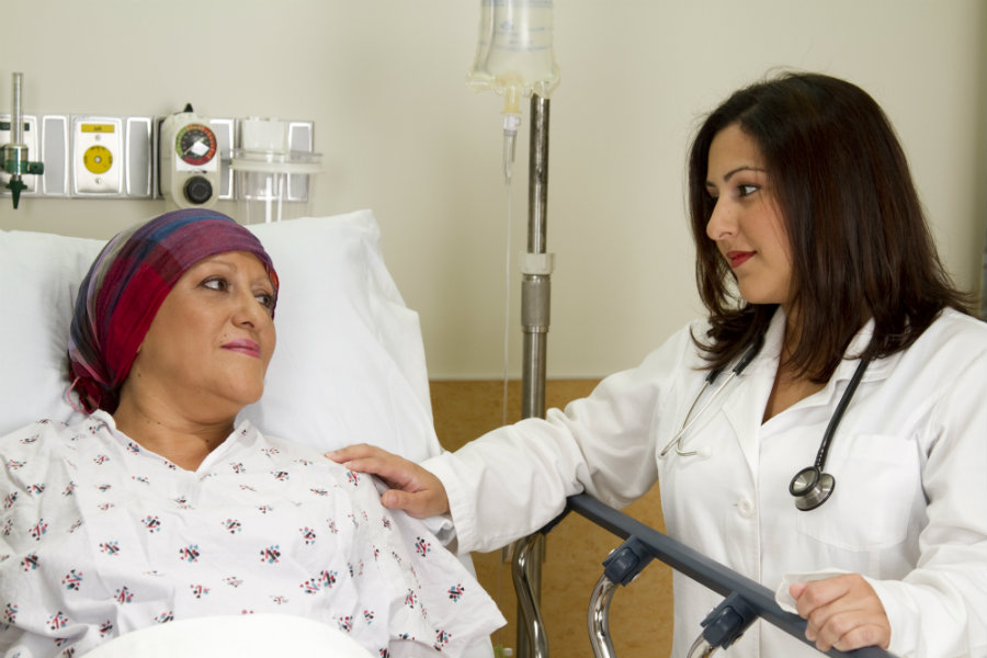 Médico junto a una paciente en cama.