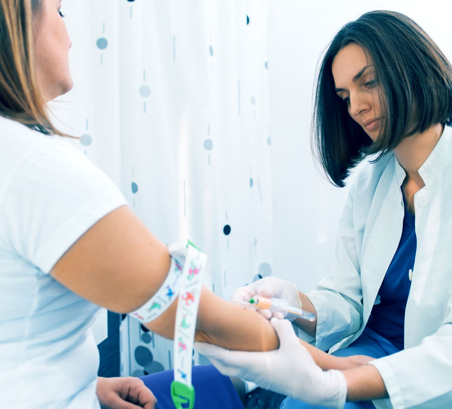 A photo of a female doctor drawing blood from a patient