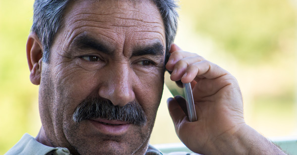 Hispanic men outside on cell phone