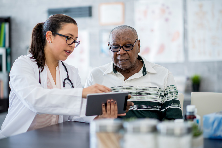 A doctor sharing information with a patient using a tablet computer.