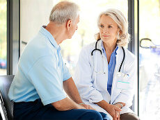 Elderly male patient talking with female doctor