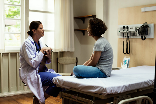 Doctor talking with her patient in an examining room