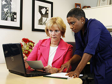 two women looking at a computer