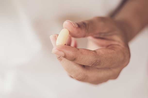 hand holding large pill