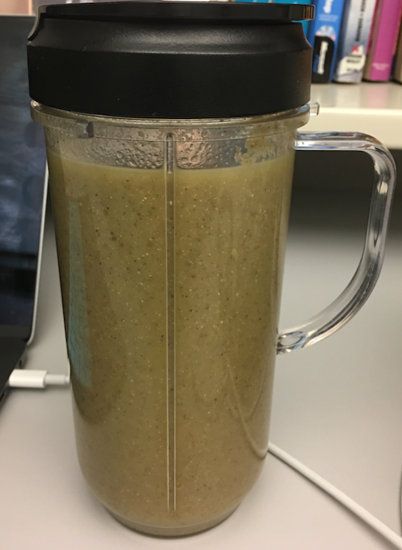 image of dark green smoothie in a glass travel container.