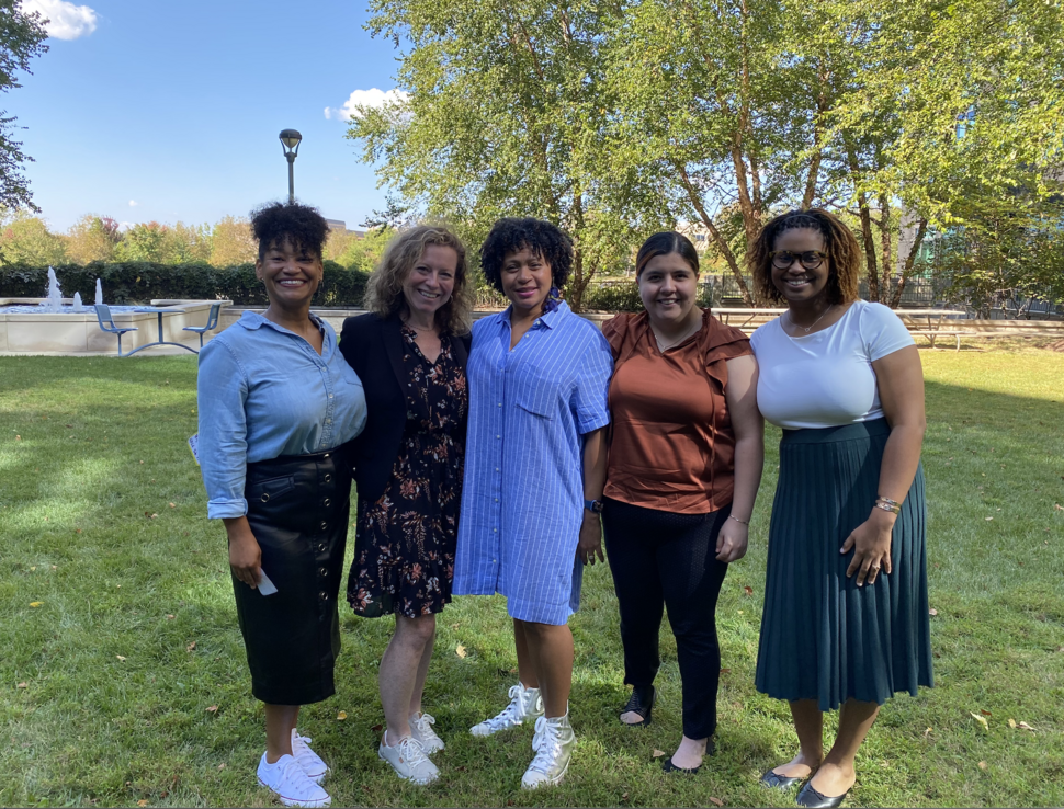 Five women, members of the KPGA research team, standing in a row outside and smiling