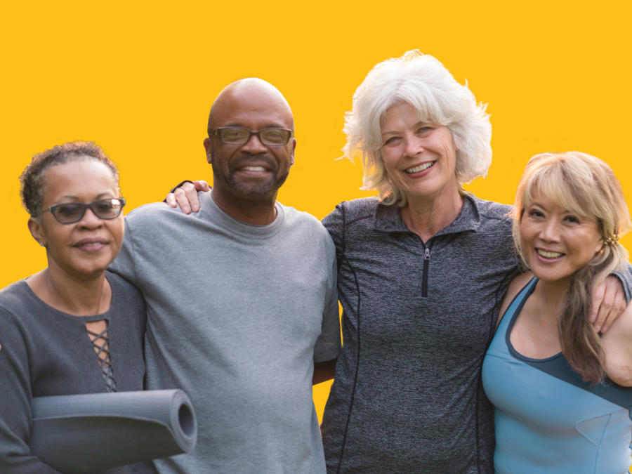 A group of diverse older adults standing together with their arms around each other looking to camera
