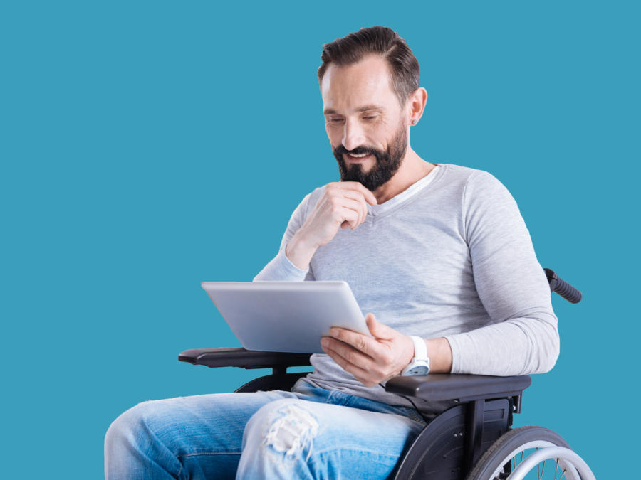 A man in a wheelchair looking at information on a tablet