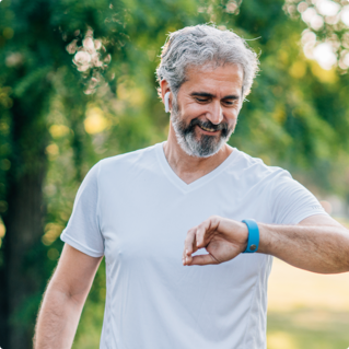 A man is outside being active and checking his smart watch