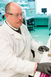 Barry Neun wears a labcoat in a lab
