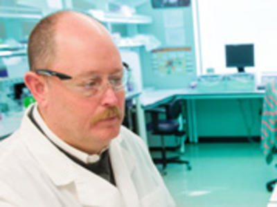 Barry Neun wears a labcoat in a lab