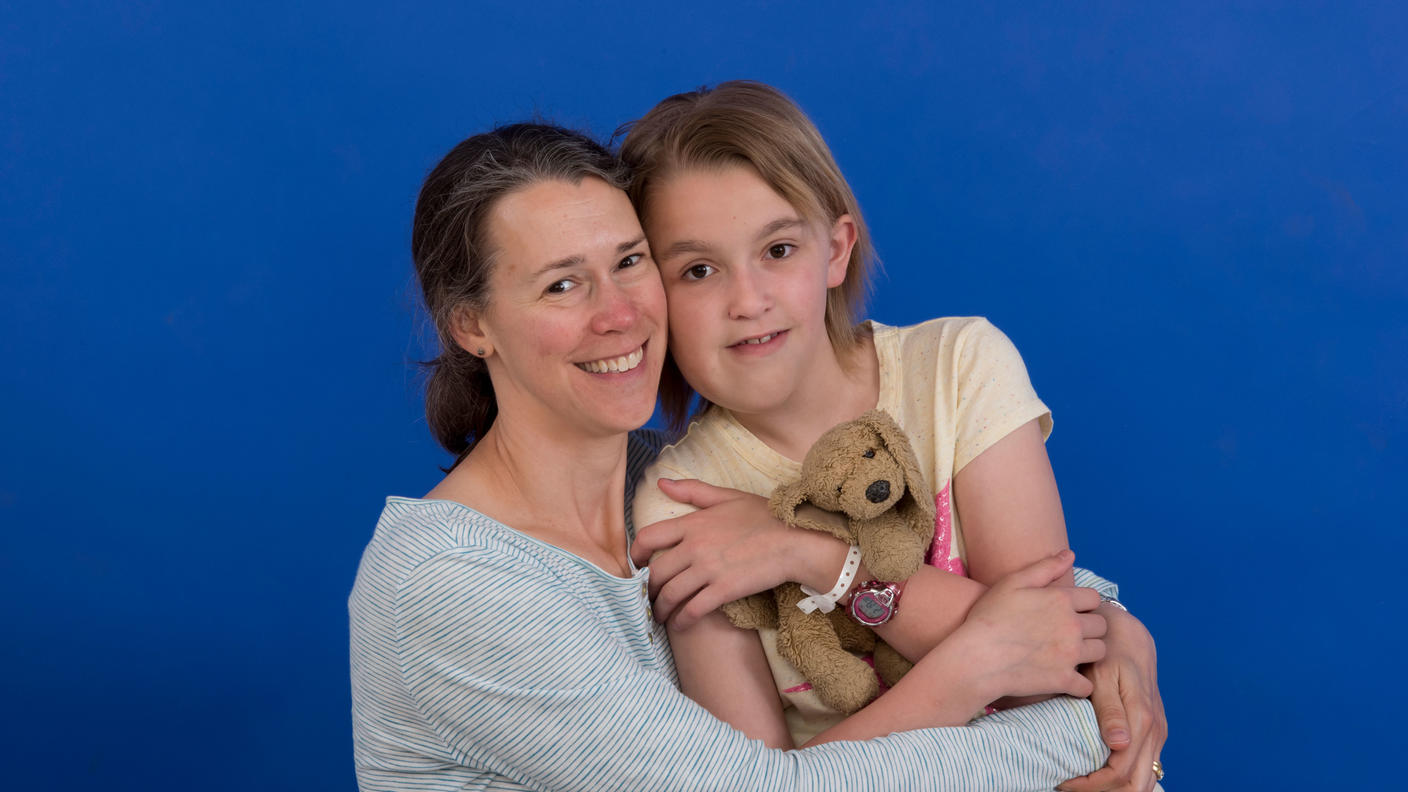 Woman hugs her daughter who was treated with selumetinib as part of a clinical trial.