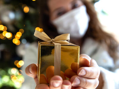 Girl with mask holding wrapped present