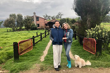 Marcela and her husband at their home with their dog