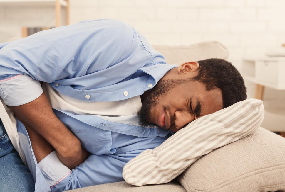 Man lying in bed with a stomach ache