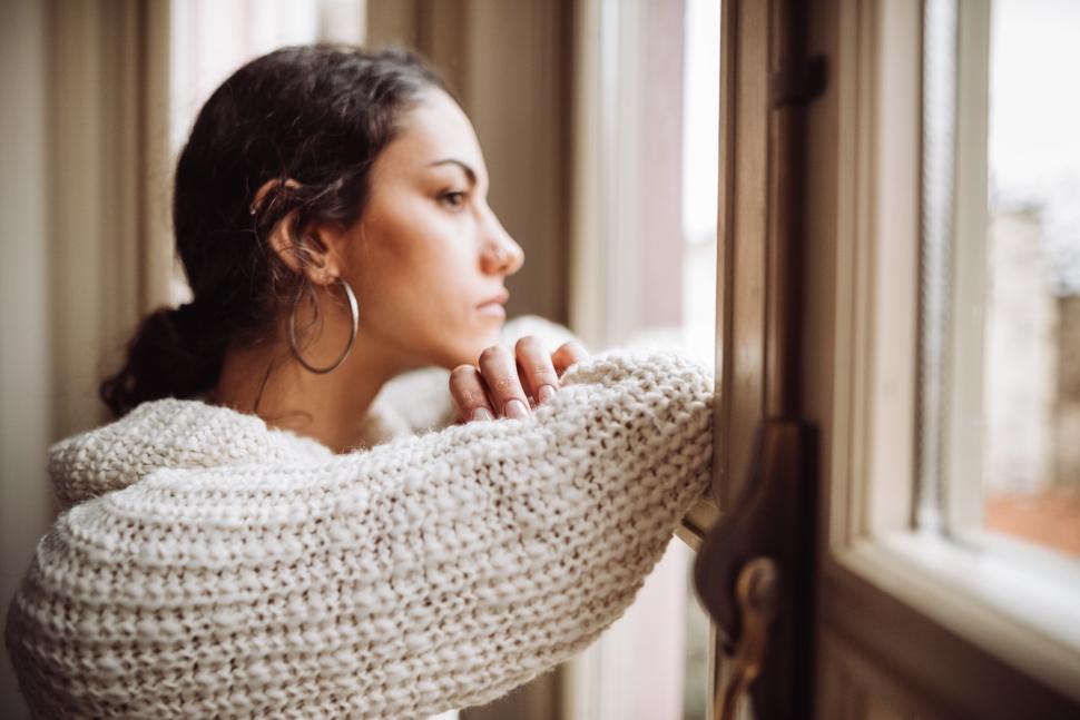 Girl looking sad out a window