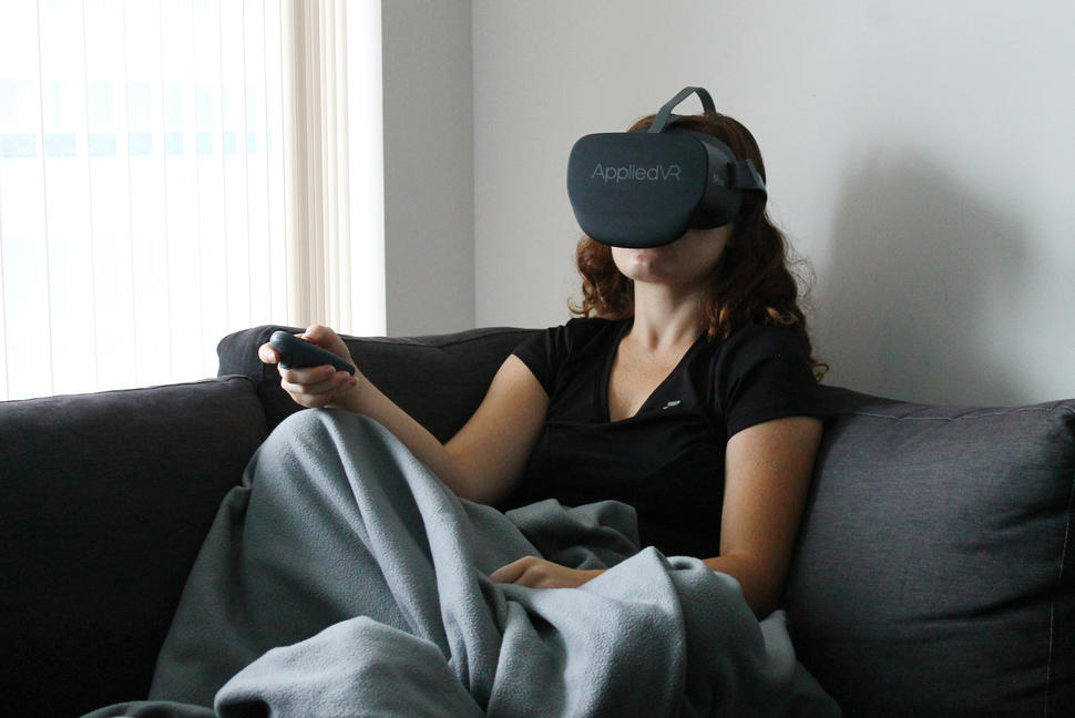 Girl sitting on couch using a virtual reality headset