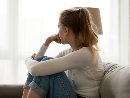 Girl sitting on couch looking out of window