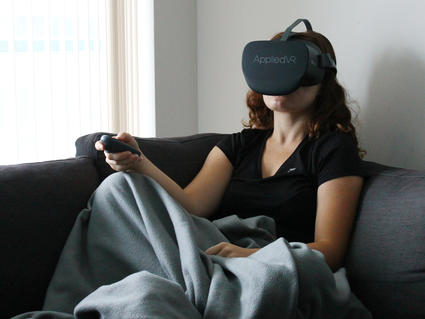 Girl sitting on couch using a virtual reality headset