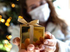 Girl with mask holding wrapped present