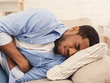 Man lying in bed with a stomach ache