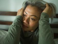 Woman holding her head in pain while crying