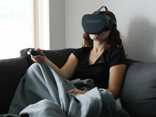 Girl sitting on couch using a virtual reality headset