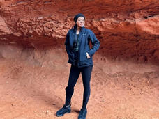 Dalouny standing outside a natural rock formation