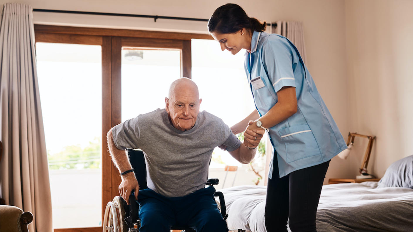 A man in a wheelchair getting assistance from a nurse