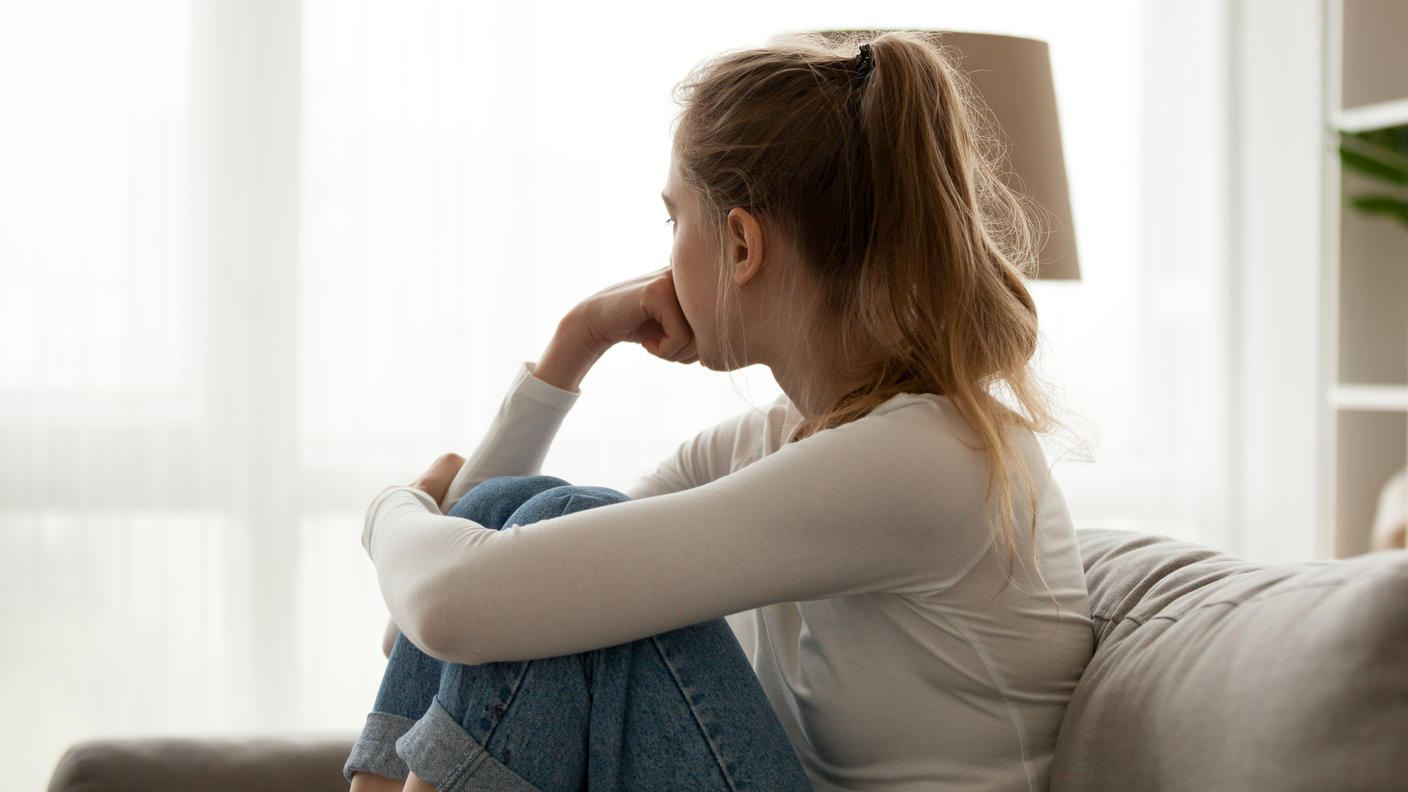Girl sitting on couch looking out of window