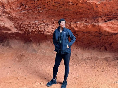 Dalouny standing outside a natural rock formation