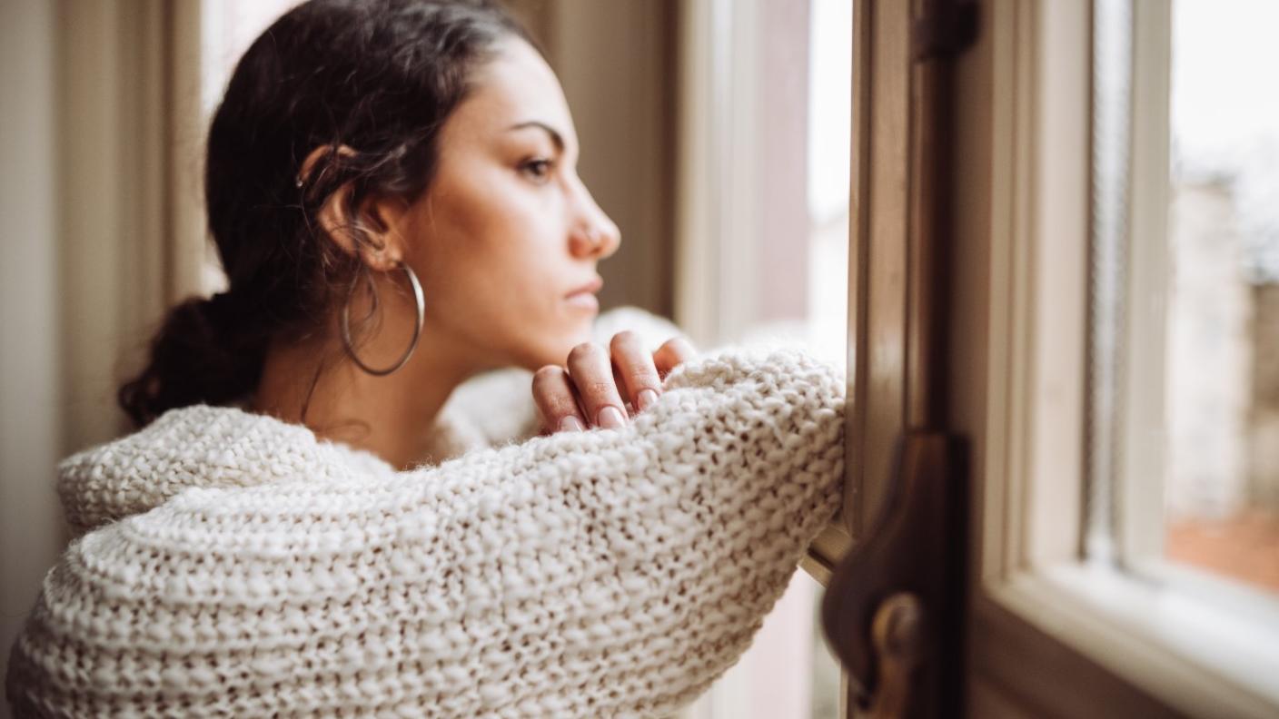 Woman looking sad while gazing out the windo