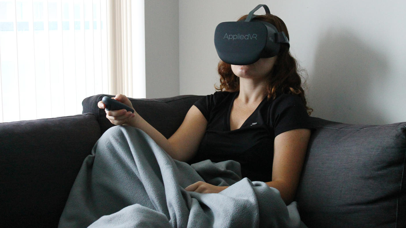 Girl sitting on couch using a virtual reality headset