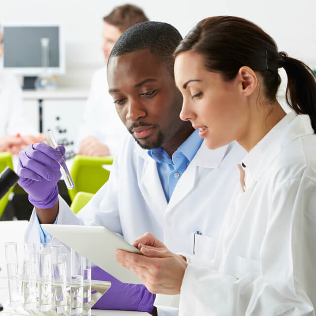 Two scientists examining a test tube.