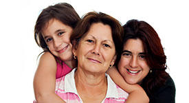 Tres generaciones de mujeres de una familia sonrien.