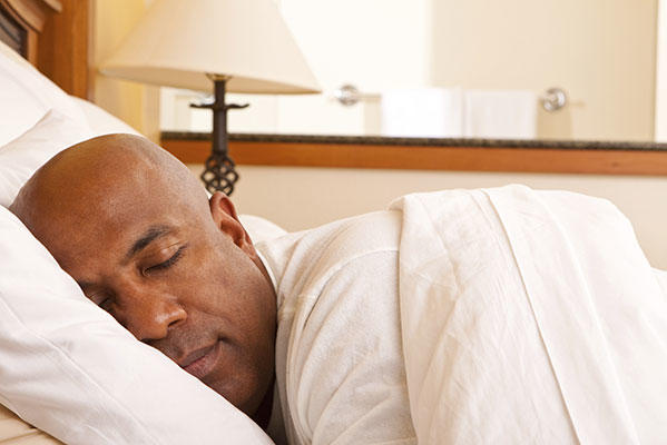 Man with cancer who is getting good night’s sleep in a comfortable bed. 