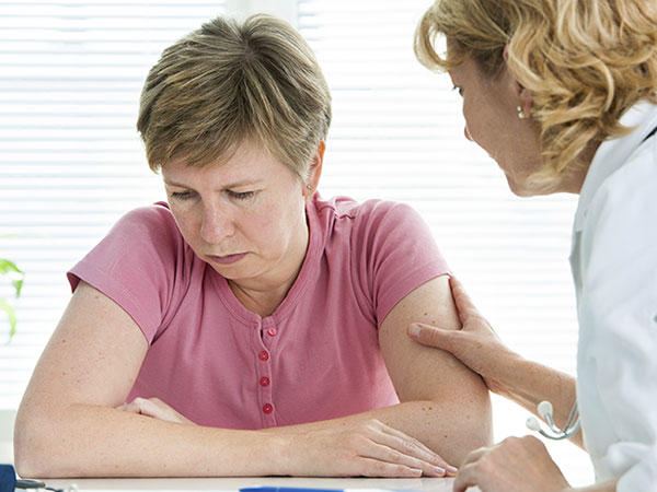 Doctor reassuring her patient who looks very tired. 