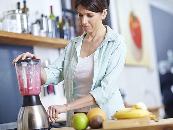 Woman making a simple and nutritious smoothie using fruit.