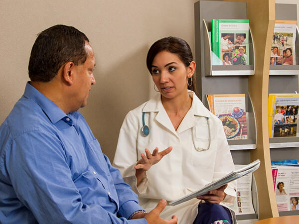 young female doctor speaks with middle-aged Latino man