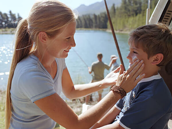 mother applying sun screen on child's face