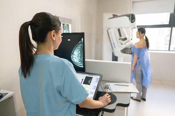 Woman undergoes mammography with health care provider.