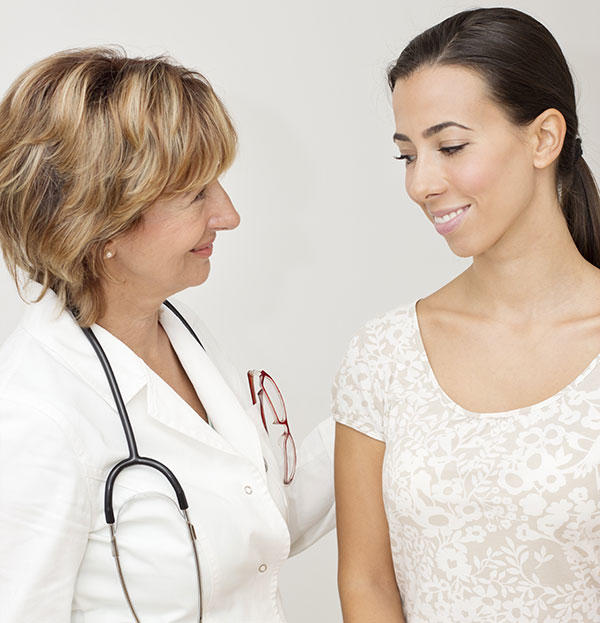 Female doctor talking with an appreciative, young female cancer patient.