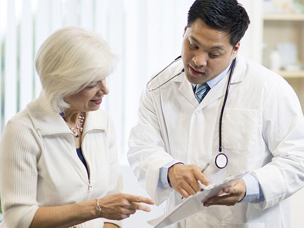 Doctor showing and explaining written information to a patient.