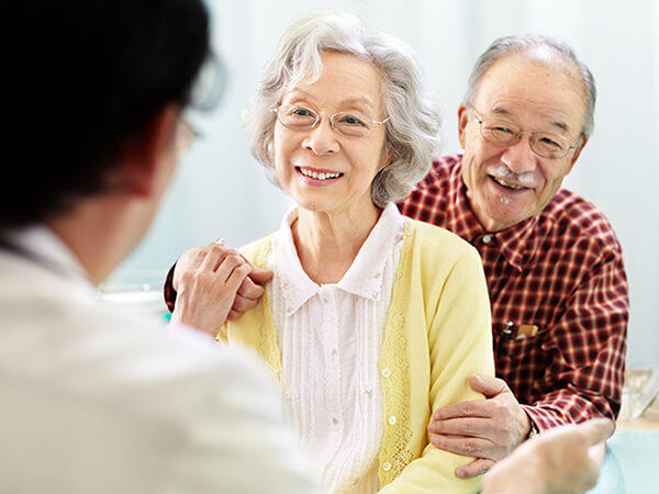 A doctor explaining how to prevent edema to an older woman and her husband. 