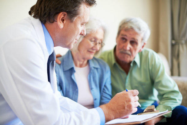 Un médico revisando los resultados de pruebas con una pareja de adultos mayores.