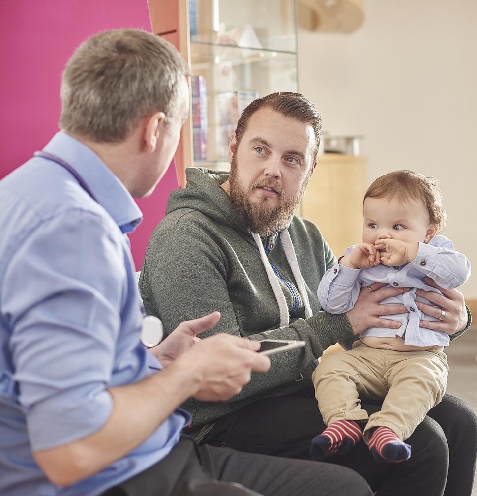 A father speaking with his toddler's pediatrician.