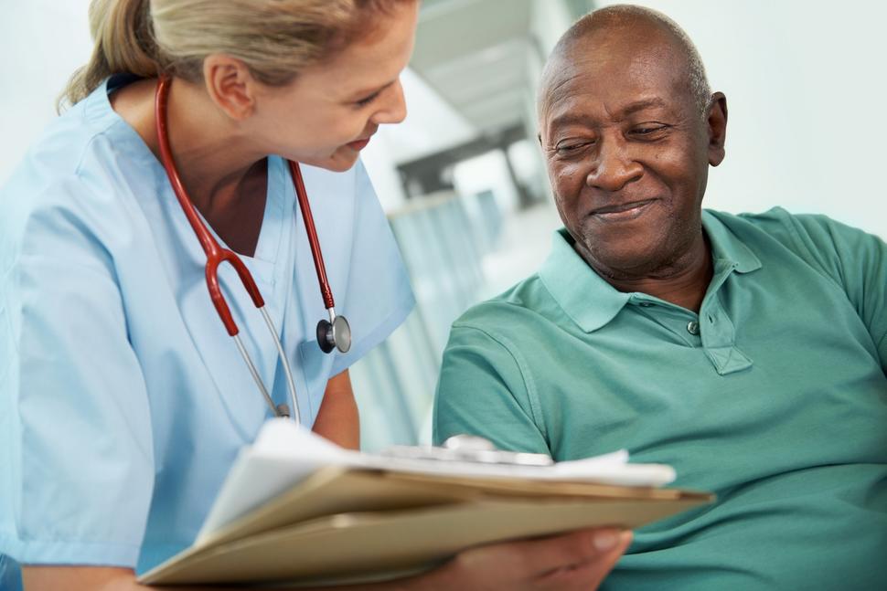 A nurse showing an African American man his test results.